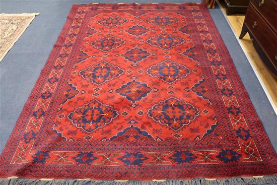 An Afghan design red ground carpet 285 x 195cm